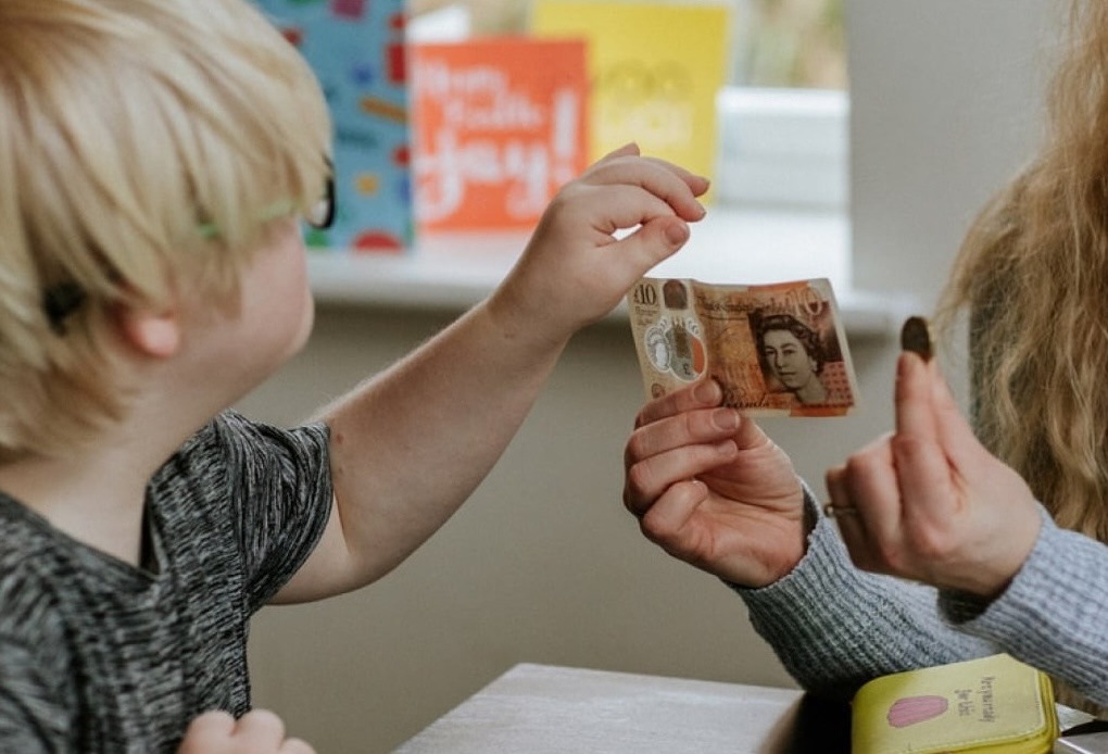 Woman holding up money to a child
