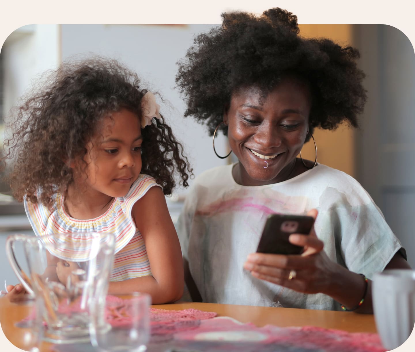 Mother and daughter sat at kitchen table